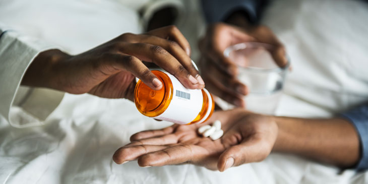 close-up of hands both dispensing and receiving medicine